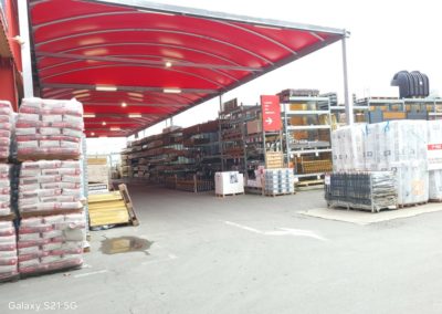 Abri avec toile tendue rouge, destiné à protéger les matériaux en libre-service au Brico Dépôt de Cannes-Écluses.